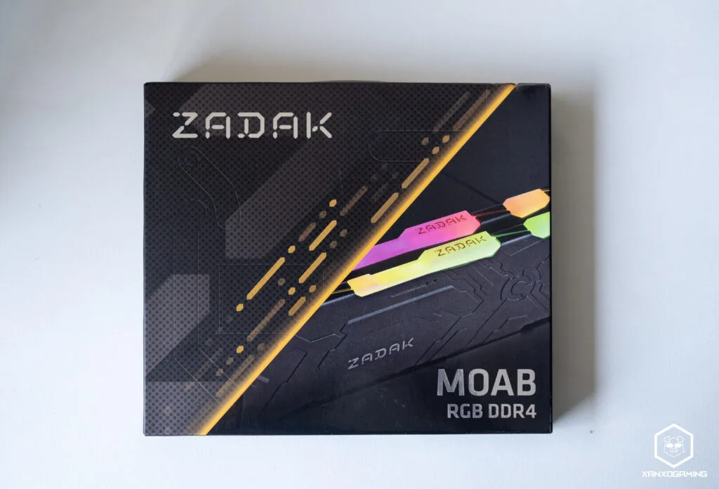 Caja de memoria RAM ZADAK MOAB RGB DDR4, con diseño moderno y colores vibrantes en la parte superior, sobre fondo negro.