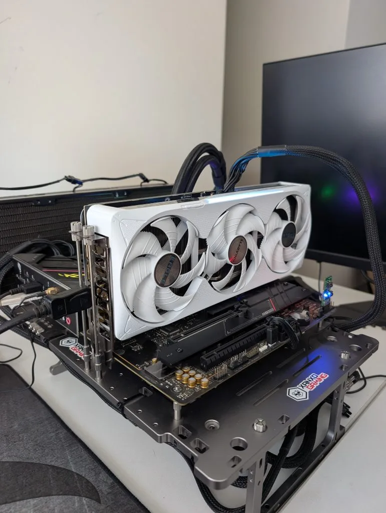 Tarjeta gráfica GIGABYTE GeForce RTX 5070 Ti EAGLE OC ICE SFF con ventiladores blancos, montada en un soporte sobre una mesa con conexionado visible.
