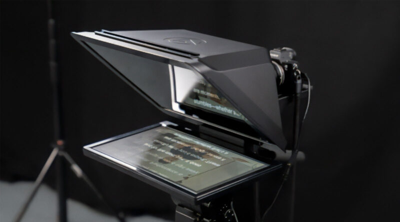 Teleprompter grande con pantalla y espejo, montado en soporte, sobre fondo oscuro, diseñado para uso en estudio.