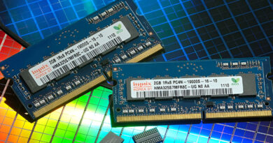 Módulos de memoria RAM sobre una superficie brillante con patrones de colores, destacando sus etiquetas y conectores dorados.