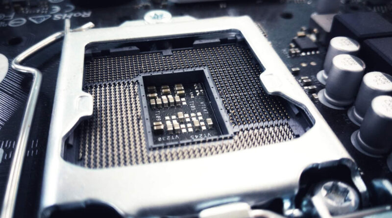 Socket de CPU en una placa base, con conectores dorados en un fondo negro. Elementos metálicos brillantes alrededor.