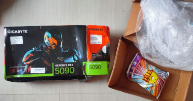 Caja de la tarjeta gráfica Gigabyte RTX 5090, junto a un paquete de detergente, en una superficie clara.