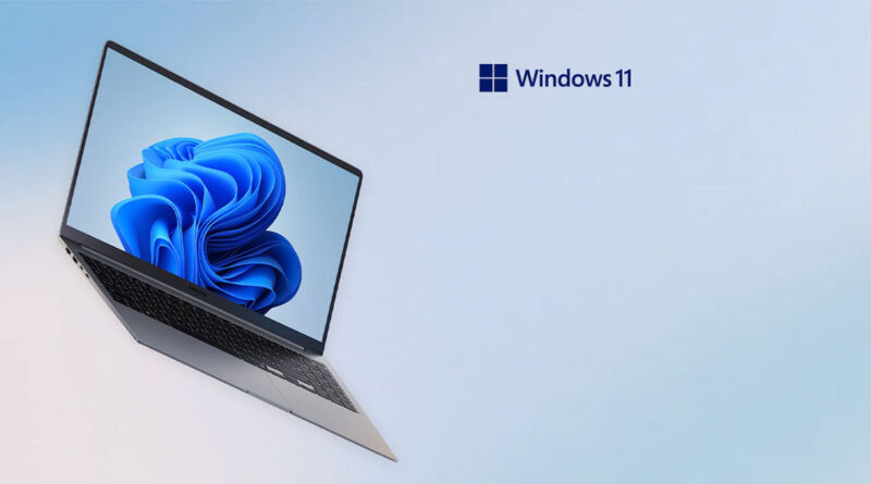 Portátil moderno con pantalla que muestra el logo de Windows 11, sobre un fondo suave en tonos azules.