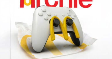 Controlador de videojuego blanco con ganchos amarillos sobre una servilleta arrugada, fondo sencillo con el nombre "Archie" en rojo.