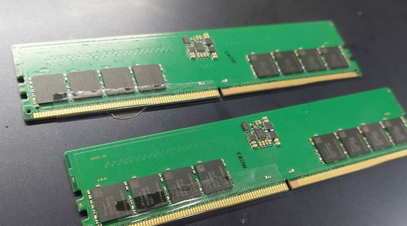 Dos módulos de memoria RAM, con PCB verde y chips de memoria oscura, colocados en una superficie gris oscura, muestra el diseño interno.