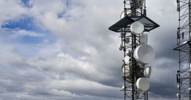 Antenas de telecomunicaciones en una torre, con un cielo nublado y azul de fondo, resaltando la infraestructura de conectividad.