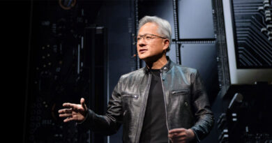 Jensen Huang, con chaqueta de cuero y gafas, habla en un escenario con fondo de circuitos y componentes tecnológicos.