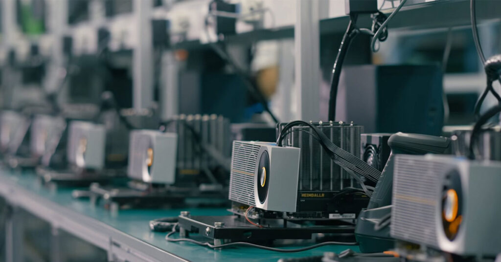 Vista de una línea de producción con varias GPUs en sus bases, con disipadores de calor en un entorno industrial bien iluminado.