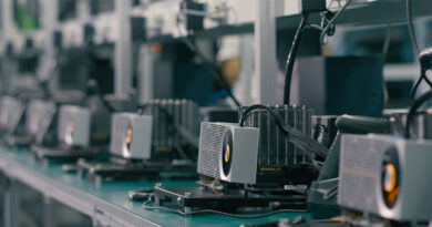 Vista de una línea de producción con varias GPUs en sus bases, con disipadores de calor en un entorno industrial bien iluminado.