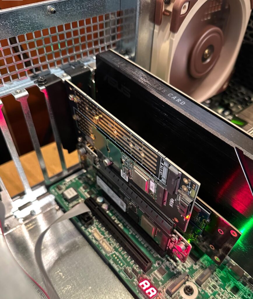 Adaptador PCIe instalado en una placa base, con una GPU y conexiones NVMe visibles, en un chasis con iluminación LED.