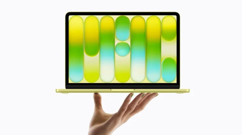 Un MacBook dorado sostenido por una mano, mostrando una pantalla con formas geométricas en tonos verdes y amarillos.