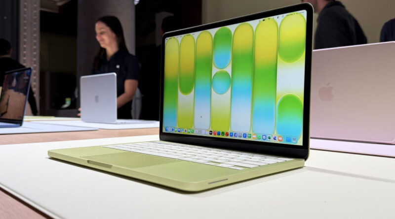 Laptop en color verde claro con pantalla brillante que muestra un fondo en tonos amarillos y verdes, colocada sobre una superficie clara.