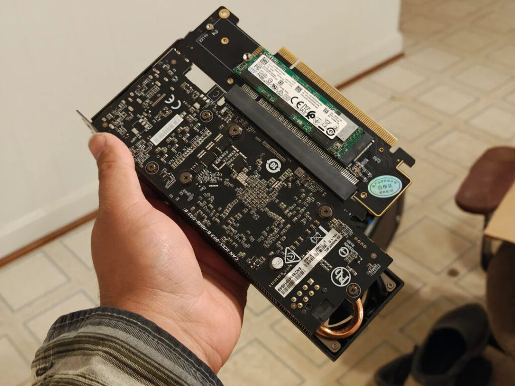 Adaptador PCIe en mano, con un diseño negro y componentes internos expuestos, permite la conexión de una GPU low profile y un módulo NVMe.