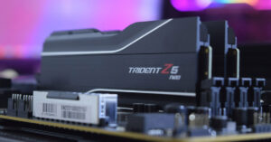 Módulo de RAM Trident Z5 Neo sobre una placa madre, con un fondo difuso en tonos morados y azules. Diseño moderno y elegante.