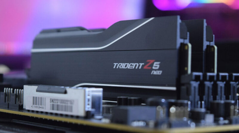 Módulo de RAM Trident Z5 Neo sobre una placa madre, con un fondo difuso en tonos morados y azules. Diseño moderno y elegante.