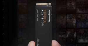 SSD WD Black SN850X en mano, con fondo oscuro, destacando su diseño elegante y el logo de Western Digital en colores negro y naranja.