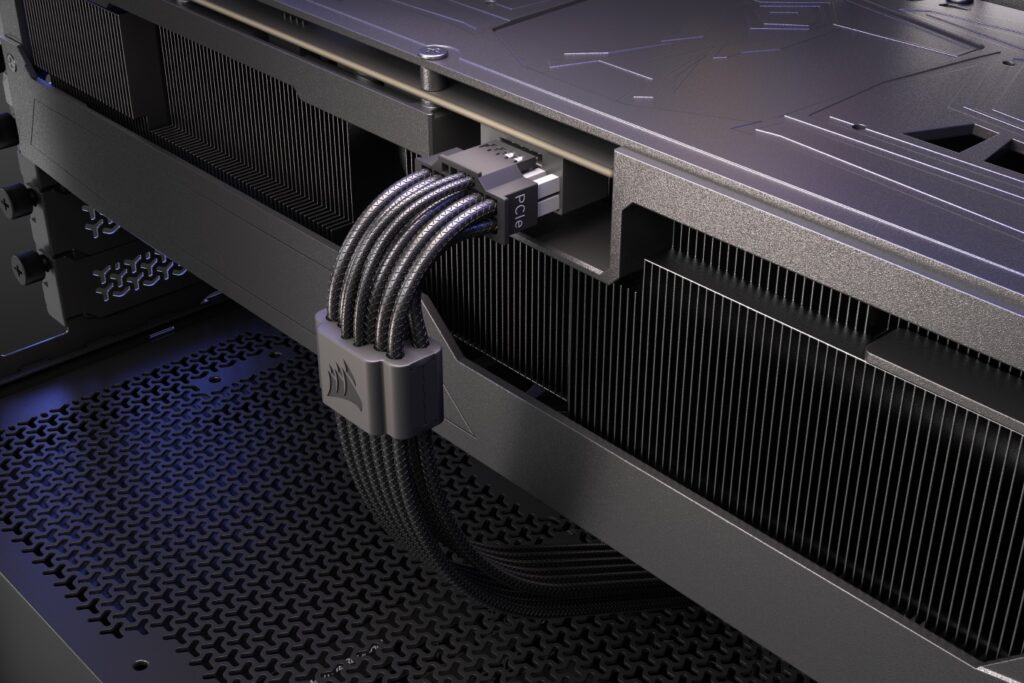 Cable de alimentación de 16 pines de Corsair conectado a una GPU, con un fondo oscuro y texturizado de componentes de hardware.