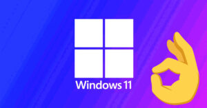 Fondo degradado en azul y púrpura con el logo de Windows 11 y una mano haciendo el símbolo de "ok".