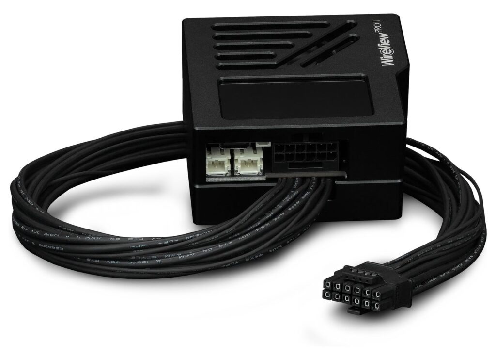 Dispositivo de teclado con un diseño negro compacto, cables conectores en un lado, y una rejilla de ventilación en la parte superior.