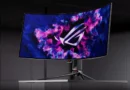 Monitor curvo OLED con fondo colorido y diseño moderno, exhibiendo el logotipo ROG en la pantalla, sobre una base elegante.