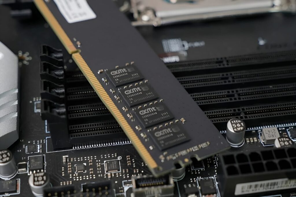 Módulo de memoria DDR5 sobre una placa base negra, con chips visibles y ranuras para instalación de memoria.