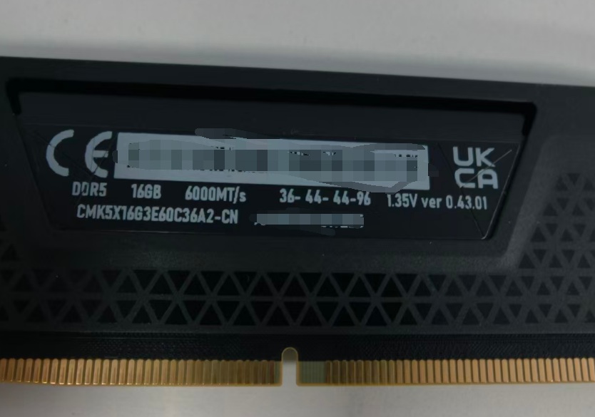 Módulo de RAM DDR5, 16GB, 6000MT/s, con etiquetas técnicas en fondo negro y dorado. Detalles de velocidad y voltaje visibles.
