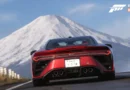 Deportivo rojo en una carretera con montaña nevada al fondo, destacando el logotipo de Forza Horizon 6 en la esquina superior.