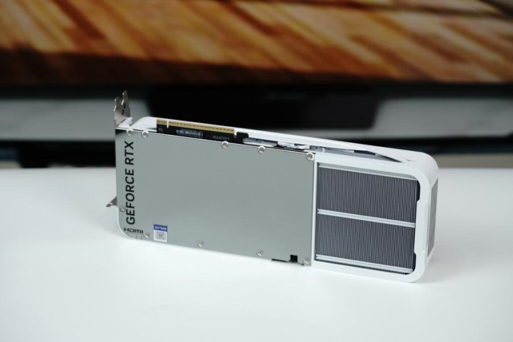 Tarjeta gráfica GeForce RTX 5070 LUNA OC con diseño blanco y placa trasera espejo, exhibida sobre una superficie blanca.