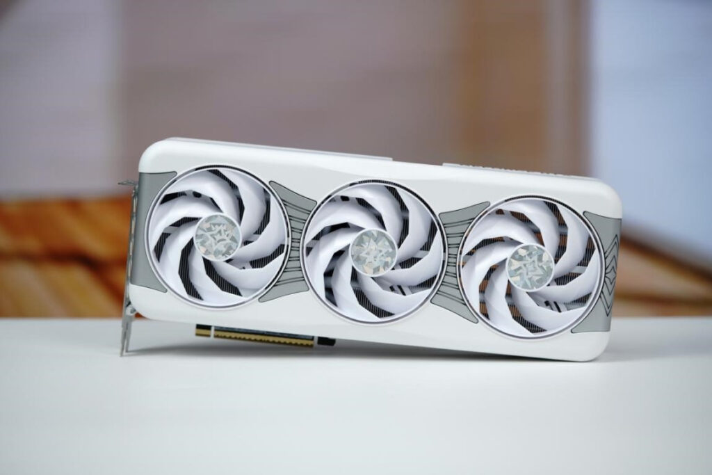 Tarjeta gráfica blanca con tres ventiladores en espiral, destacando un diseño exclusivo y moderno, colocada sobre una superficie clara.