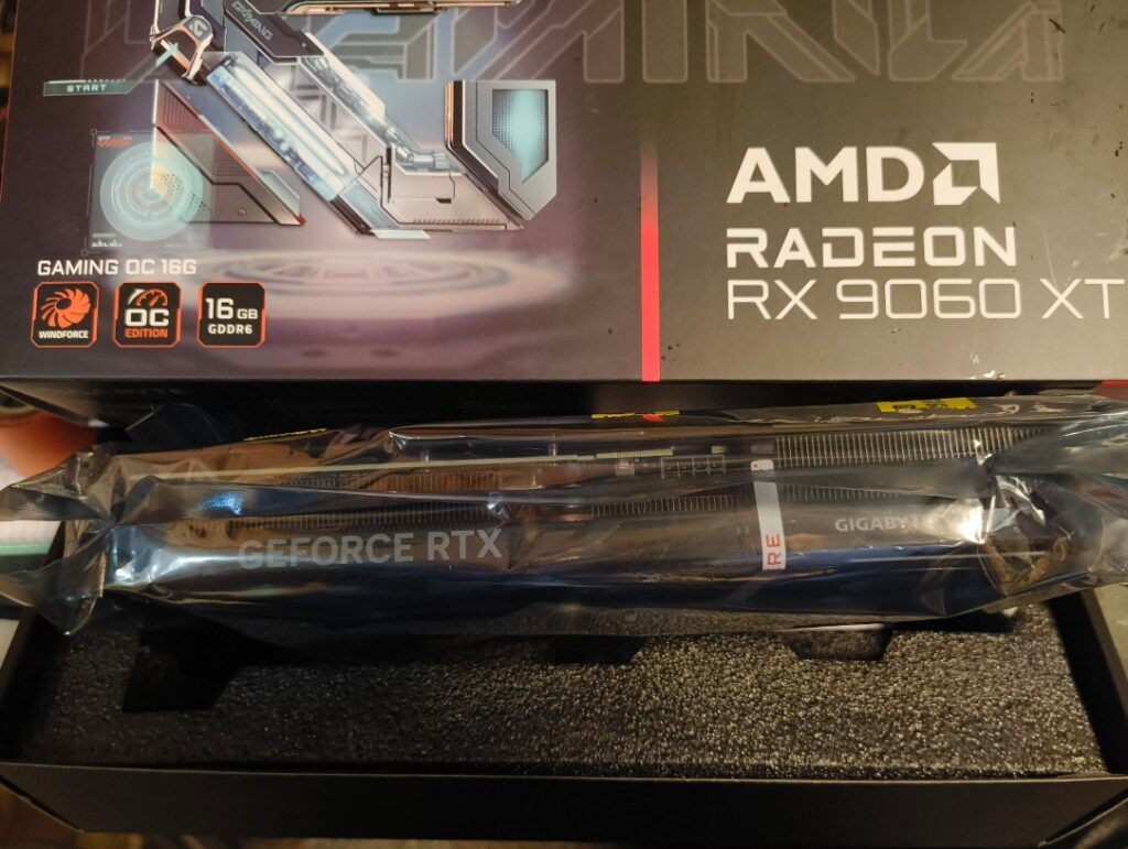 Tarjeta gráfica AMD Radeon RX 9060 XT sobre una caja, con detalles visibles del modelo y sus especificaciones, fondo oscuro.
