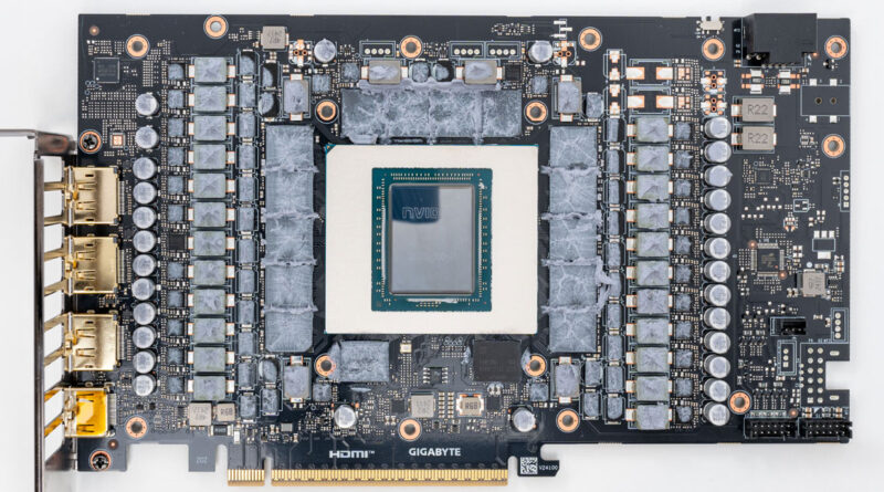 Placa de vídeo GIGABYTE con GPU en el centro, rodeada de circuitos y resistores, en tono negro y gris, con conectores en un lado.