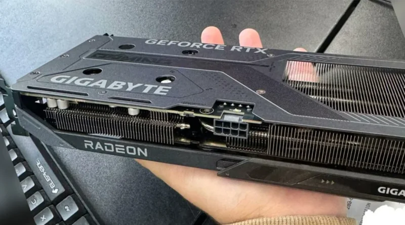 Tarjeta gráfica Gigabyte RTX 5060 Ti con disipador de Radeon, sostenida en una mano, en un fondo de mesa oscura.