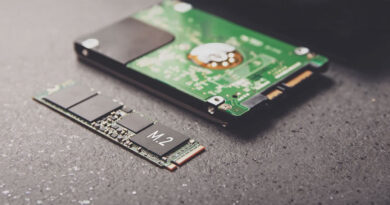 SSD M.2 en primer plano junto a un disco duro tradicional, sobre un fondo oscuro con detalles metálicos y circuitos.