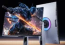 Monitor gaming con diseño futurista; pantalla brillante mostrando un guerrero mecánico y luz RGB en la parte trasera.