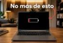 Portátil en un escritorio con un fondo moderno. Pantalla negra muestra un ícono de batería baja y texto "No más de esto".
