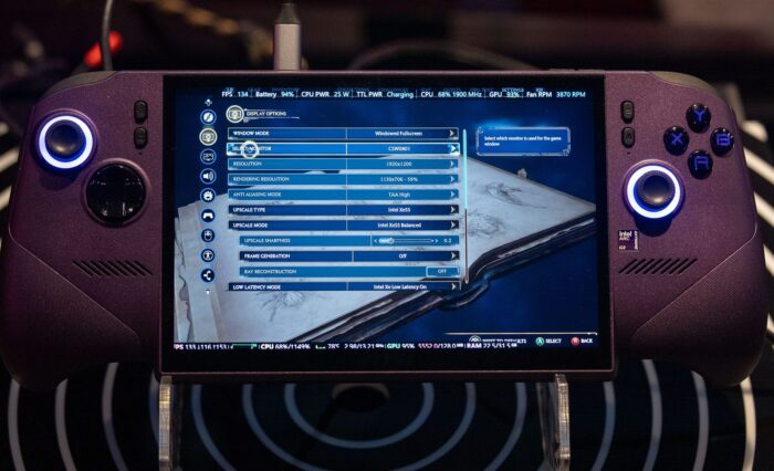 Controlador de juego con pantalla, mostrando un menú de configuración técnica, botones azules iluminados y fondo oscuro.