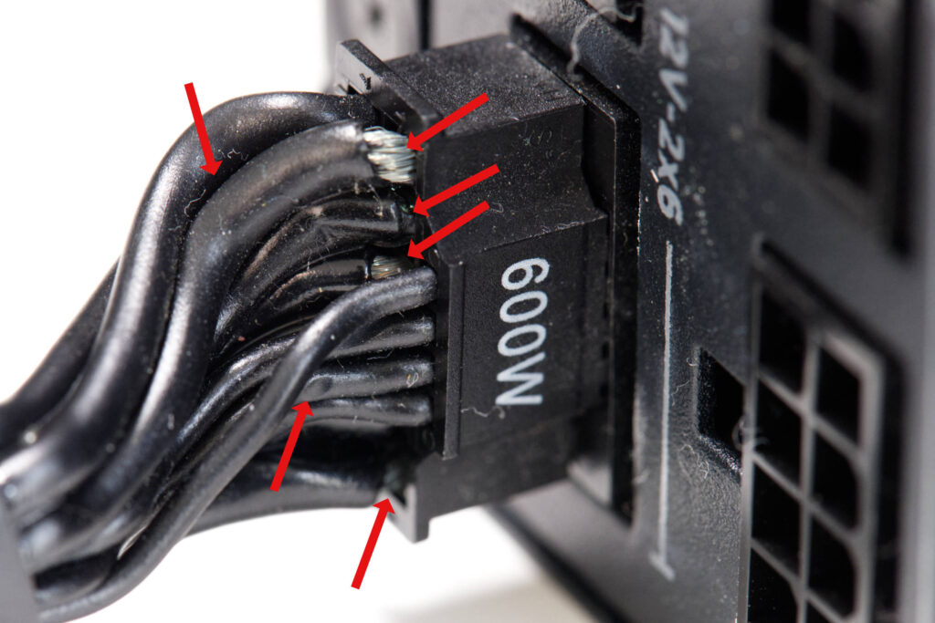 Conector de alimentación de GPU con cables dañados y signos de sobrecalentamiento, resaltando el conector de 600W.
