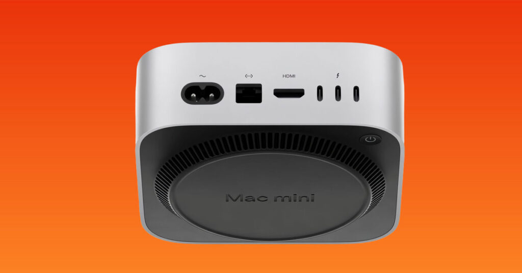 Mac mini en fondo naranja, vista superior con puertos eléctricos, HDMI y Thunderbolt, diseño compacto y moderno.
