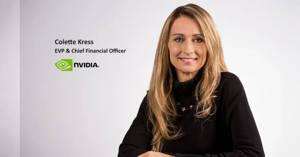 Colette Kress, CFO de NVIDIA, sonríe frente a un fondo blanco, luciendo un suéter negro y con el logo de NVIDIA a la izquierda.