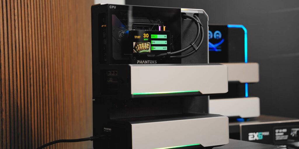 Unidad de refrigeración Phanteks con pantalla digital y luces LED verdes, presentada sobre una superficie con fondo de madera.