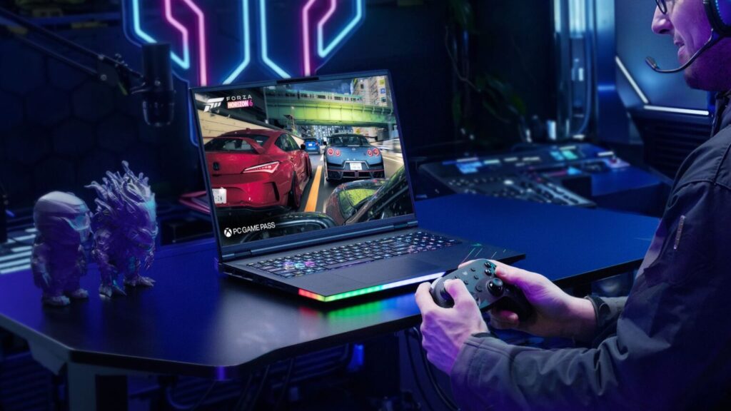 Portátil de gaming con pantalla brillante mostrando un juego de carreras, mientras una persona sostiene un control y hay luces LED de colores.