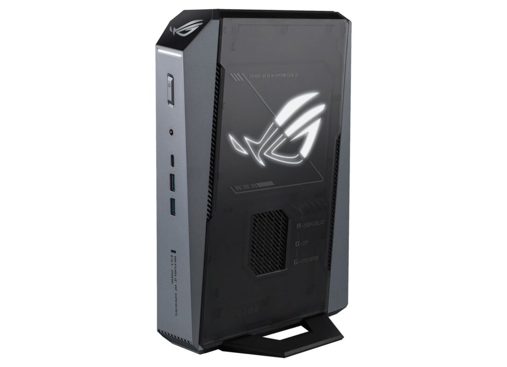 Diseño moderno de un mini PC en tonos oscuros, con el logotipo de ROG iluminado y puertos en la parte frontal.
