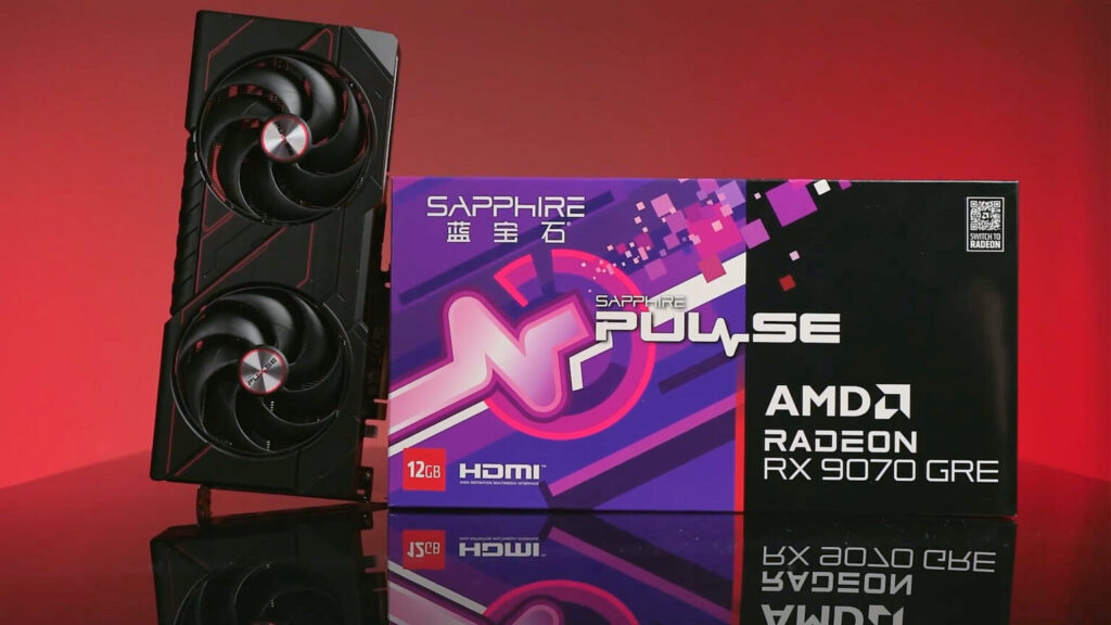 Tarjeta gráfica Sapphire Pulse AMD Radeon RX 9070 GRE en primer plano, con caja colorida de fondo en tonos morados y rojos.