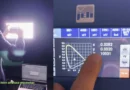 Un técnico mide la intensidad luminosa de una pantalla con un dispositivo, mostrando gráficos y datos en una pantalla digital.