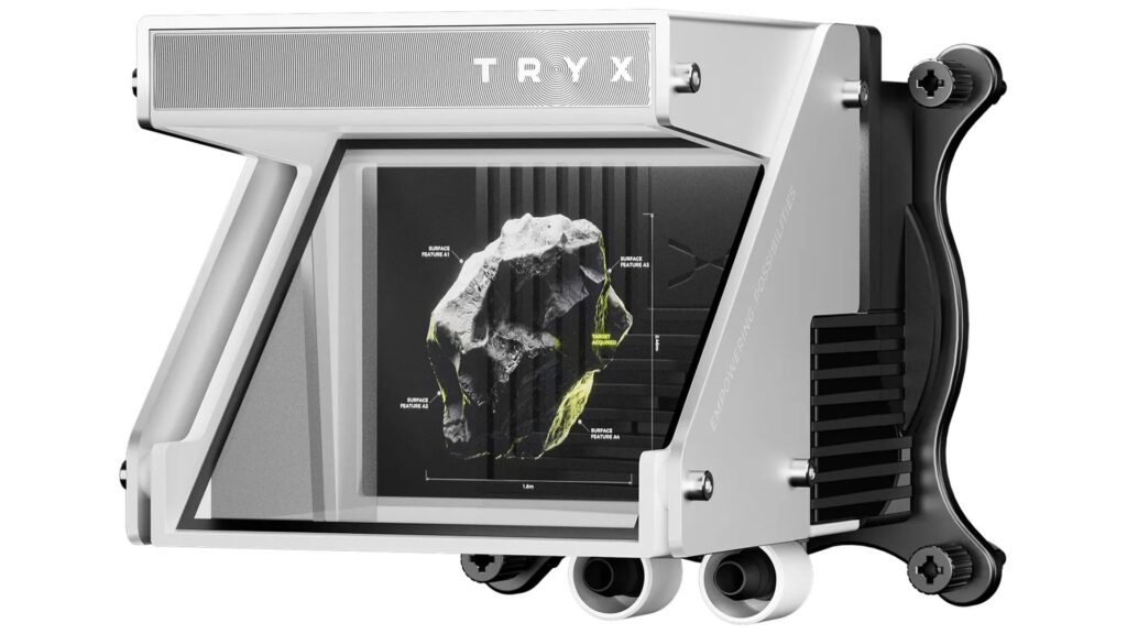 Dispositivo TRY X con diseño moderno, pantalla transparente mostrando un gráfico 3D de un objeto, colores metálicos y detalles en negro.