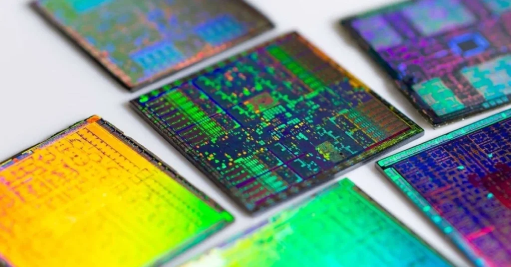 Semiconductores con patrones y colores iridiscentes, dispuestos en varias direcciones sobre un fondo claro.
