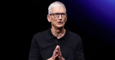 Tim Cook, director de Apple, con polo negro y gafas, gesticulando mientras habla frente a un fondo oscuro y luces moradas.