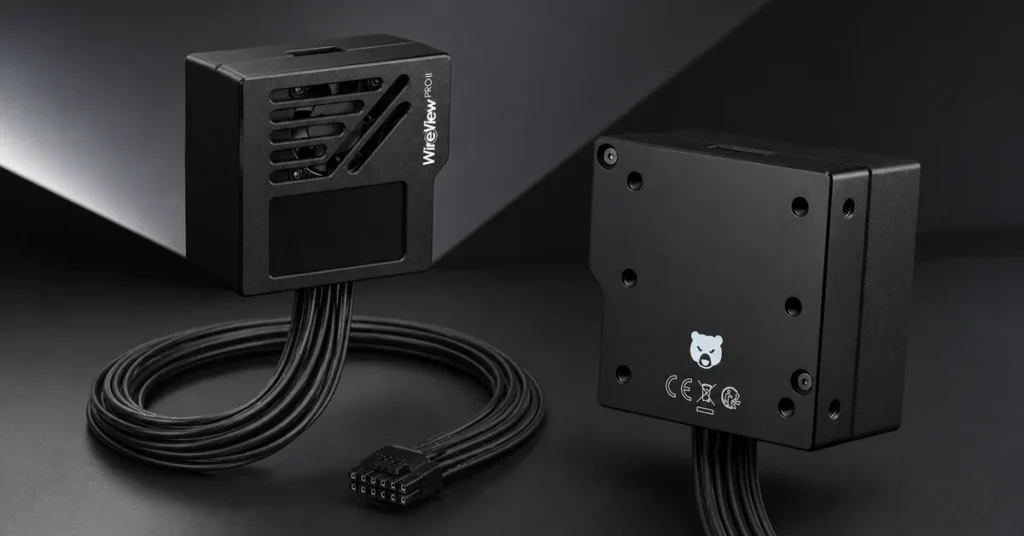 Dispositivo WireView Pro II en color negro, con conectores y cables, sobre un fondo oscuro y angular. Diseño elegante y moderno.