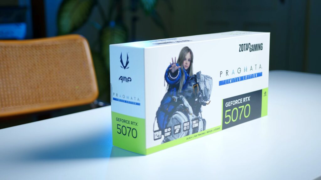 Caja de la GPU Zotac RTX 5070 AMP PRAGMATA, con ilustración de un personaje en tonos azules y verdes, sobre fondo blanco.