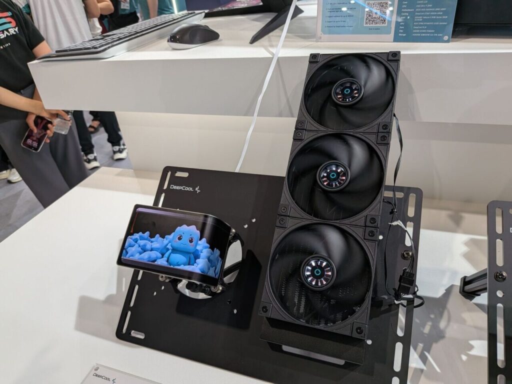 Soporte negro para un teléfono móvil con una pantalla que muestra un personaje azul, acompañado de un sistema de refrigeración con tres ventiladores negros.